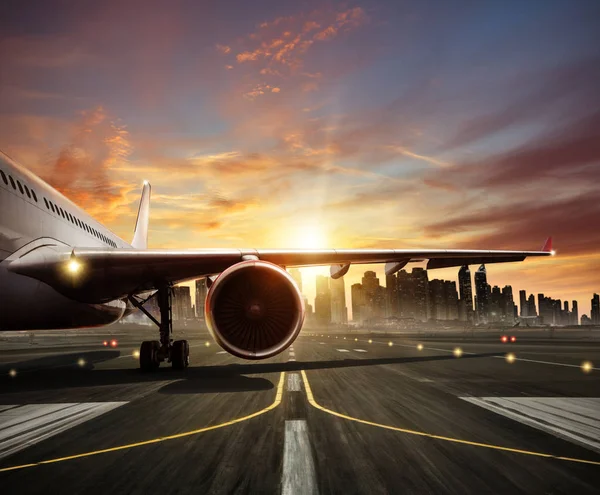 Detalle del avión comercial en la pista, ciudad moderna en el fondo — Foto de Stock