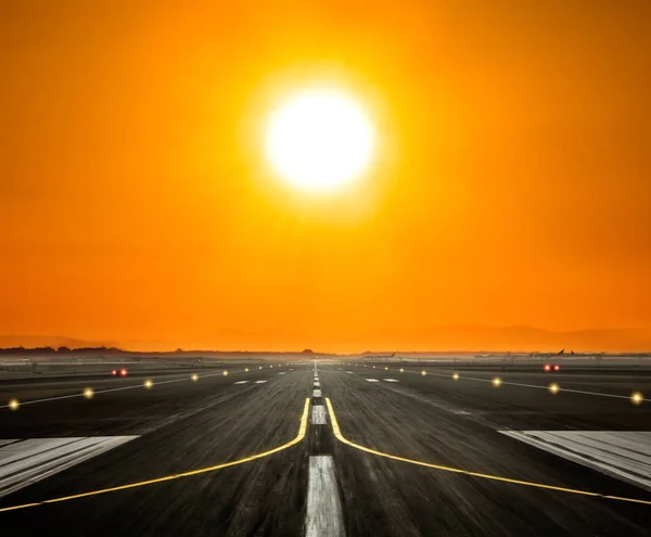 Piste de l'aéroport avec grand soleil au coucher du soleil — Photo