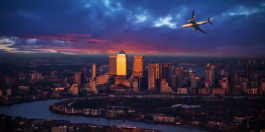 Londra şehir günbatımı ışık üzerinde uçan yolcu uçak