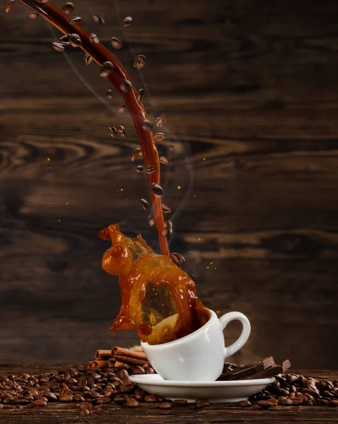 Líquido salpicante de café en taza blanca en mesa de madera —  Fotos de Stock