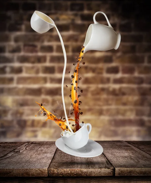 Flüssigkeit aus Kaffee und Milch in weiße Tasse auf Holztisch spritzen — Stockfoto