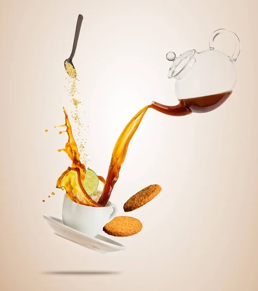 Porzellan weiße Tasse mit spritzendem Kaffee oder Tee Flüssigkeit getrennt auf braunem Hintergrund. — Stockfoto
