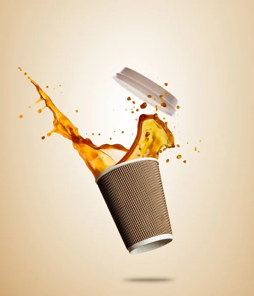 Tasse mit spritzendem Kaffee oder Tee auf braunem Hintergrund getrennt. Heißgetränk mitnehmen — Stockfoto