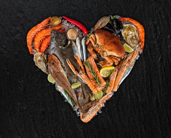 Muchos tipos de mariscos en forma de corazón. Servido sobre hielo picado — Foto de Stock