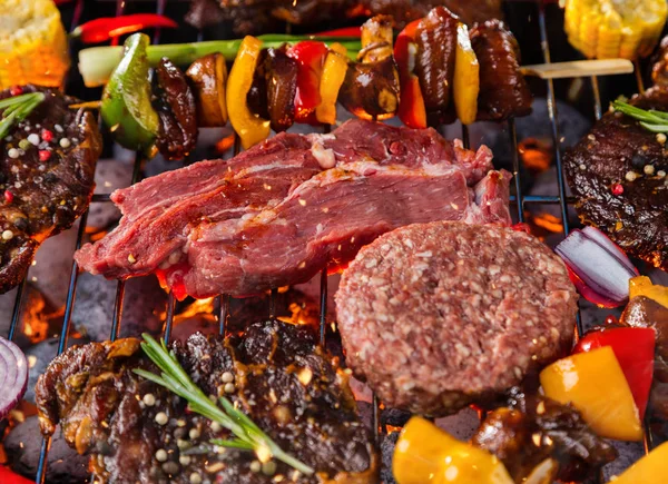 Gros plan sur la viande fraîche et les légumes sur le gril placé sur l'herbe — Photo