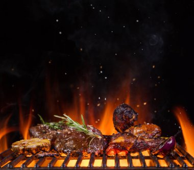 Beef steaks on the grill grate, flames on background clipart
