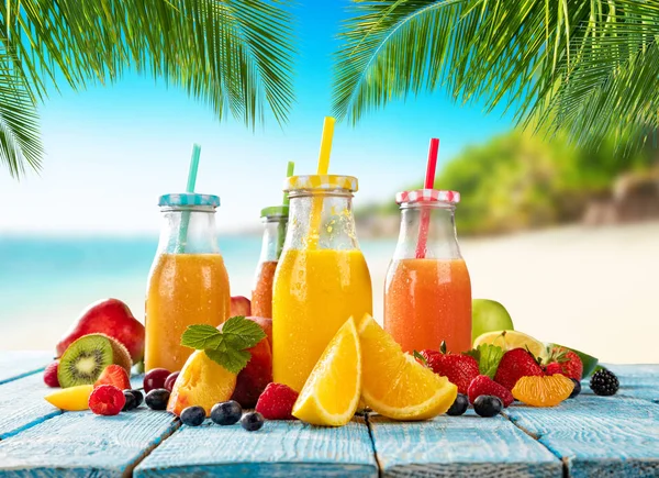 Frische Smoothie-Drinks auf Holzplanken platziert, Strand am Strand verwischt — Stockfoto