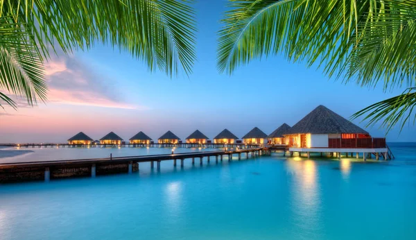 Villas aquatiques sur l'île de villégiature des Maldives au coucher du soleil — Photo