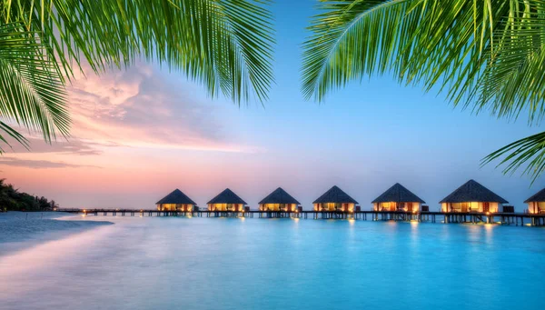 Villas aquatiques sur l'île de villégiature des Maldives au coucher du soleil — Photo