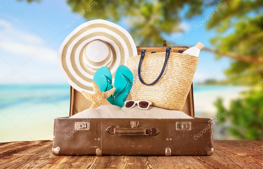 Retro luggage with summer beach holiday accessories placed on wo