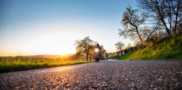 Dark motorbiker riding high power motorbike in sunset — Stock Photo, Image