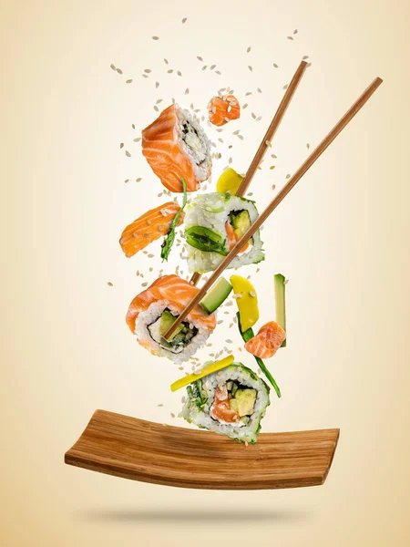 Trozos de sushi volador servidos en plato, separados en fondo de color — Foto de Stock