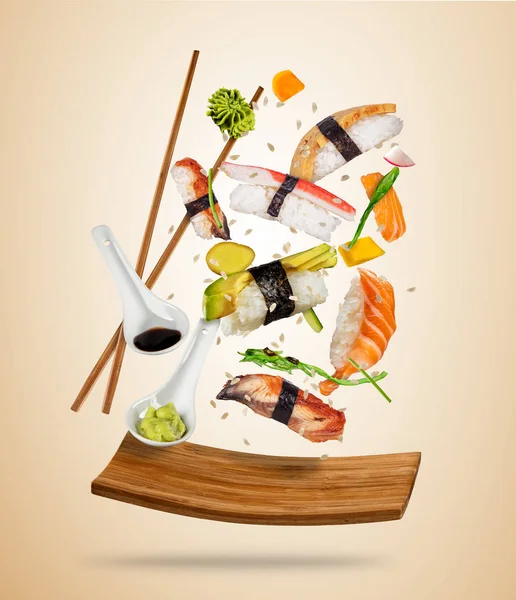 Flygande sushi bitar serveras på träplatta, separerade på färgade — Stockfoto