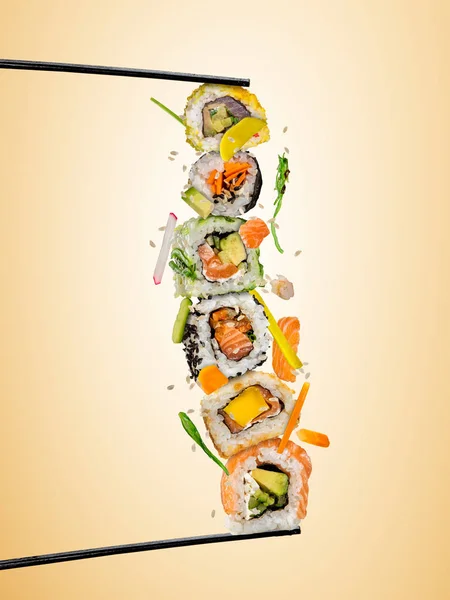 Sushi bitar placeras mellan pinnar, på färgad bakgrund — Stockfoto