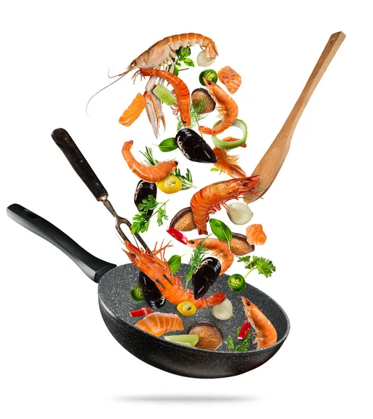 Comida marina fresca y verduras volando en una sartén sobre fondo blanco —  Fotos de Stock