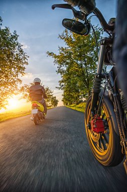 Güzel gün batımı ışığa doğru boş sürüş motosiklet binici