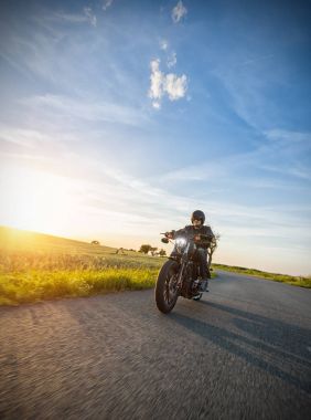 Karanlık bisikletçinin'nde Günbatımı yüksek güç motosiklet sürme