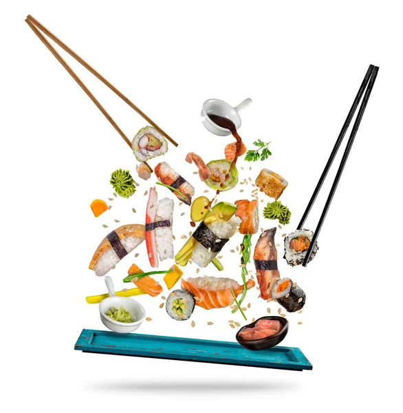 Sushi-Stücke zwischen Essstäbchen auf weißem Hintergrund — Stockfoto