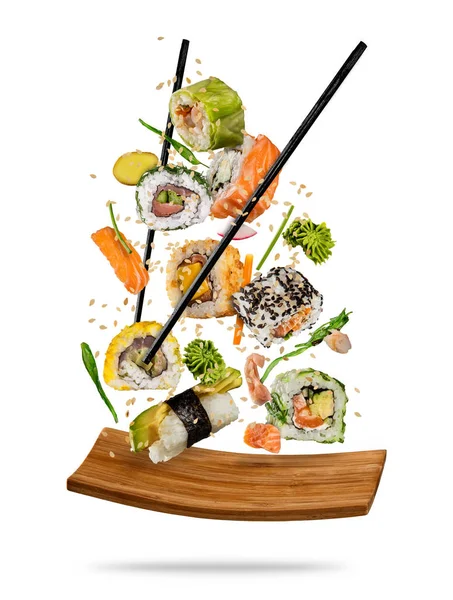 Sushi-Stücke zwischen Essstäbchen auf weißem Hintergrund — Stockfoto