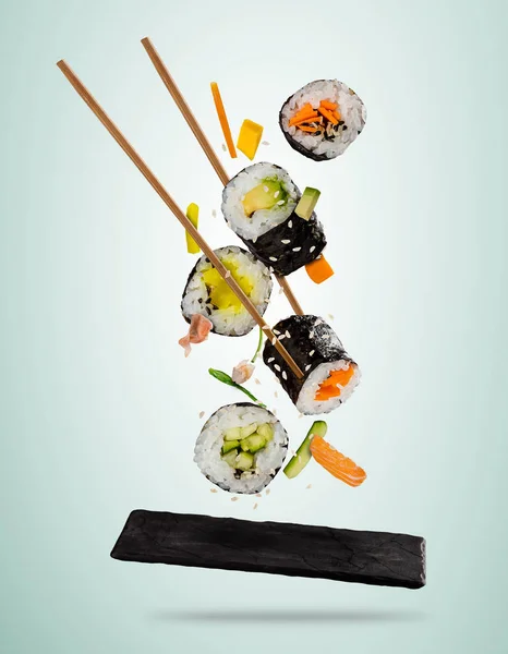 Flying sushi pieces served on stone plate, separated on soft bac — Stock Photo, Image