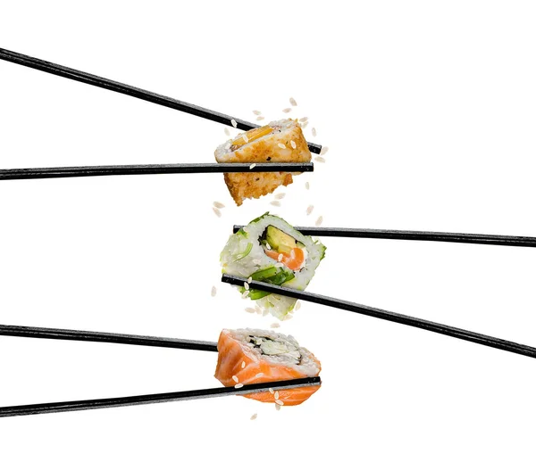 Piezas de sushi colocadas entre palillos, sobre fondo blanco — Foto de Stock