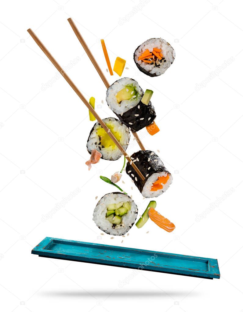 Sushi pieces placed between chopsticks on white background