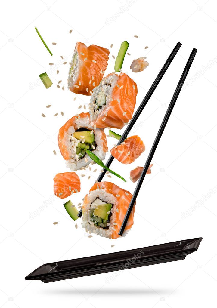 Sushi pieces placed between chopsticks on white background