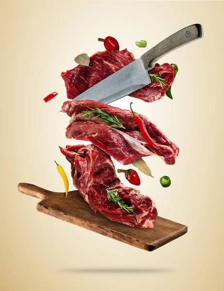 Flying raw steaks with ingredients, food preparation concept — Stock Photo, Image