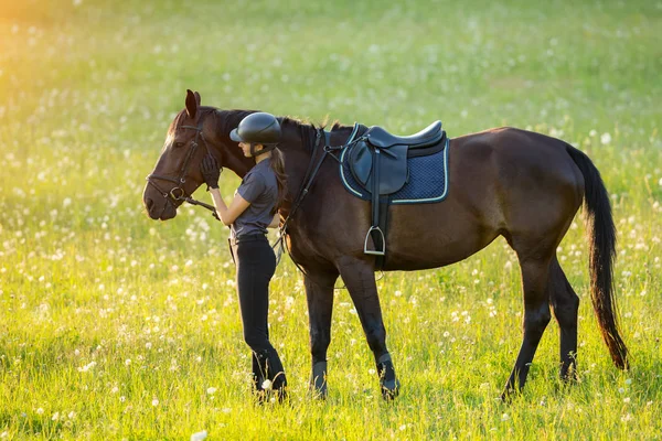 Fiatal nő lovas a lovát az esti naplemente fény — Stock Fotó