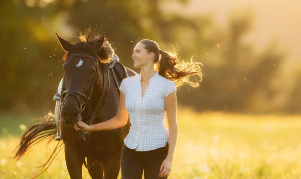 Mujer joven corriendo con su caballo en la luz del atardecer —  Fotos de Stock