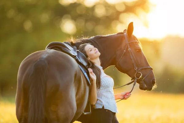 Junge Frau mit ihrem Pferd im Abendsonnenuntergang — Stockfoto
