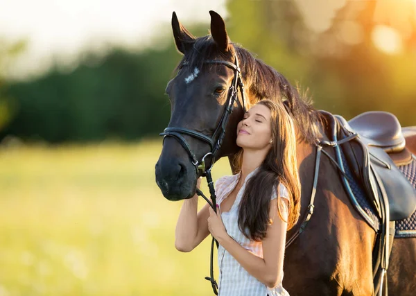 Young woman with her horse in evening sunset light — Stock Photo, Image