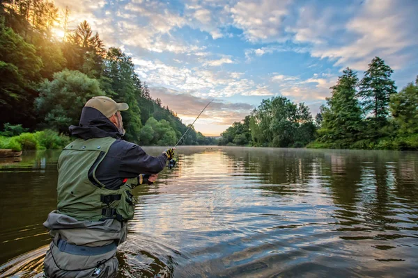 Pescador deportivo cazando peces. Pesca al aire libre en río — Foto de Stock