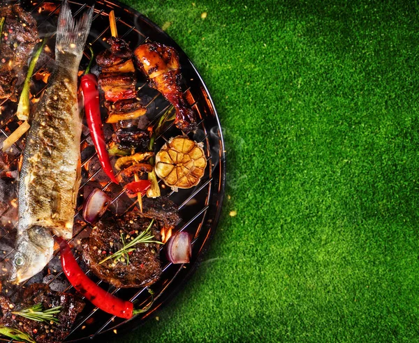 Top view of fresh meat and vegetable on grill placed on grass — Stock Photo, Image