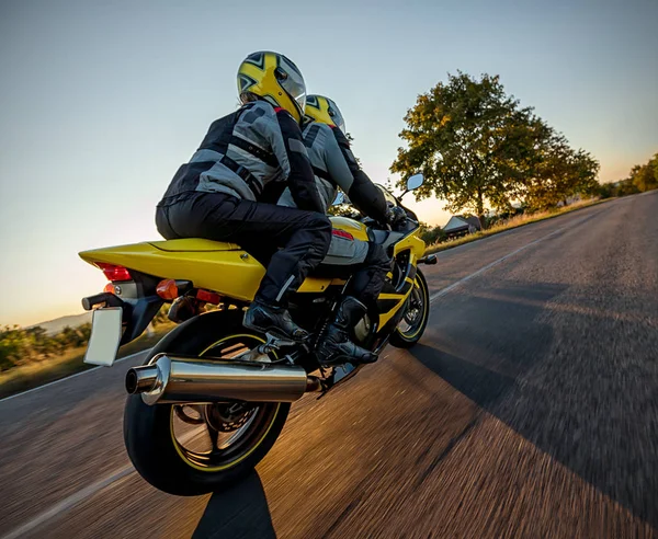 Motociclistas en moto deportiva en la puesta del sol, photog al aire libre —  Fotos de Stock