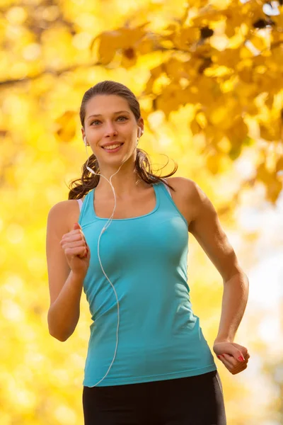 Jonge brunette vrouw die in herfst bos loopt — Stockfoto