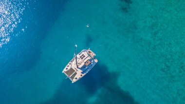 Aerial view of catamaran anchoring on coral reef clipart