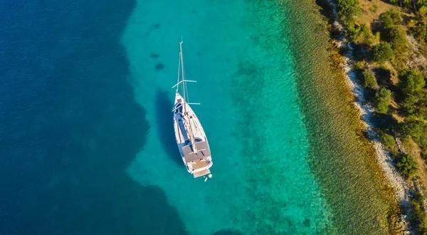 Aerial view of sailing boat anchoring next to reef — Stock Photo, Image