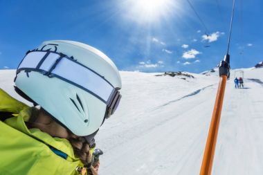Mutlu genç kadın kayakçı Kayak lift sürükleyin.