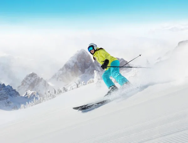 Mladá žena lyžaře běží po svahu v alpských horách — Stock fotografie