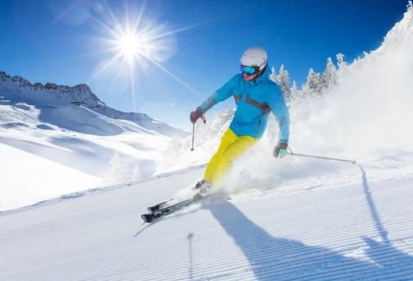 Alp Dağları'nda yamaç aşağı çalışan genç adam kayakçı