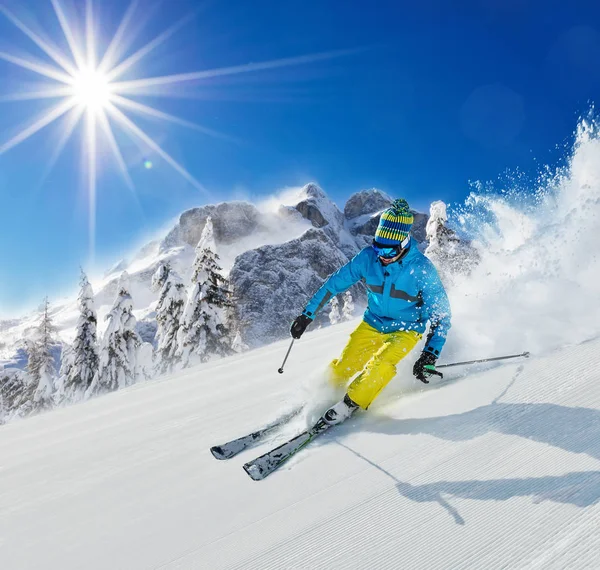 Ung man skidåkare kör ner backen i alpina berg — Stockfoto