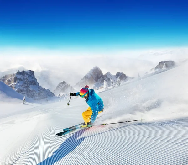 Joven esquiador corriendo por la ladera de las montañas alpinas — Foto de Stock