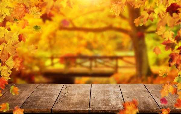 秋の背景に落ちる葉、空の木製テーブル — ストック写真