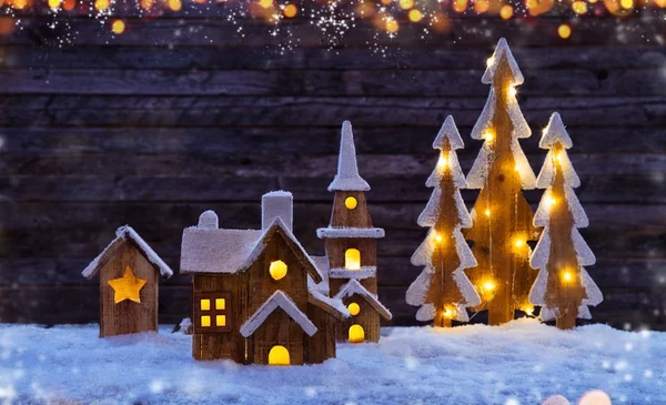 Weihnachten Hintergrund mit beleuchtetem Holzdorf und Bäumen — Stockfoto