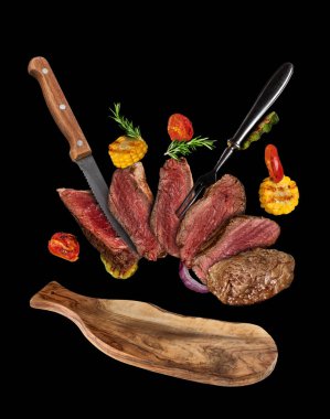 Sığır eti biftek ızgara sebze tabakta ile uçan.