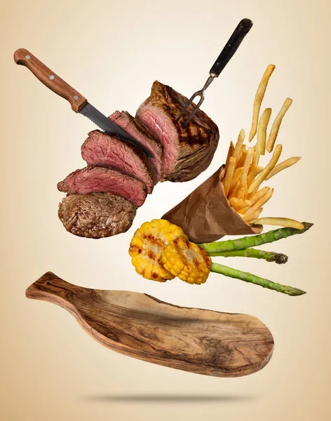 Flying beef steaks with grilled vegetable and french fries serve — Stock Photo, Image