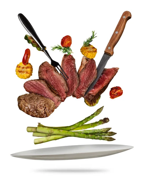 Flying beef steaks with grilled vegetable served on plate. — Stock Photo, Image