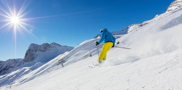 Skiër op piste lopen bergafwaarts — Stockfoto