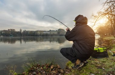Sport fisherman trying to catch fish in river, urban fishing.  clipart